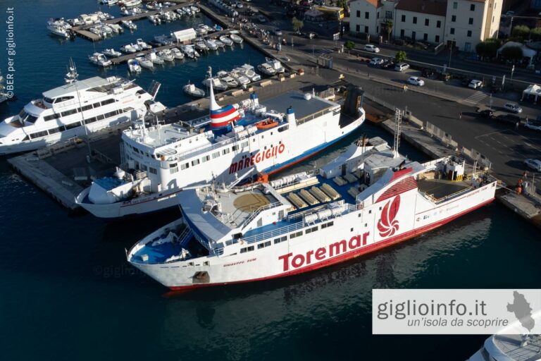 Veduta aerea con drone dei traghetti per l'Isola del Giglio della Toremar e Maregiglio nel porto della Valle, Porto Santo Stefano - Monte Argentario